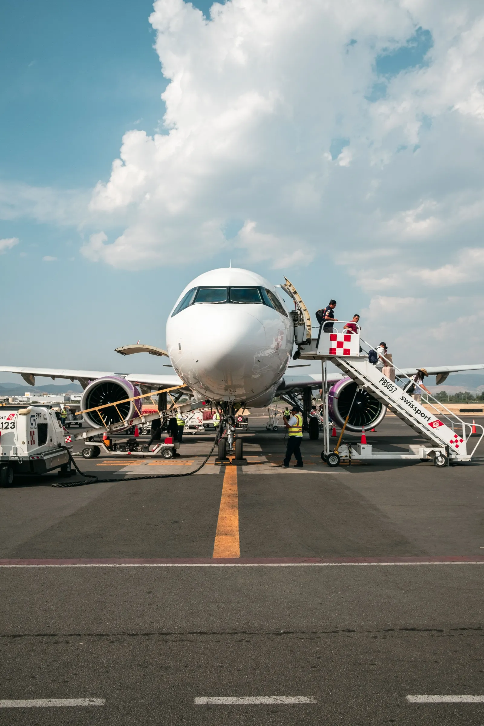 Des passagers montent l’escalier d’un avion sur le tarmac
