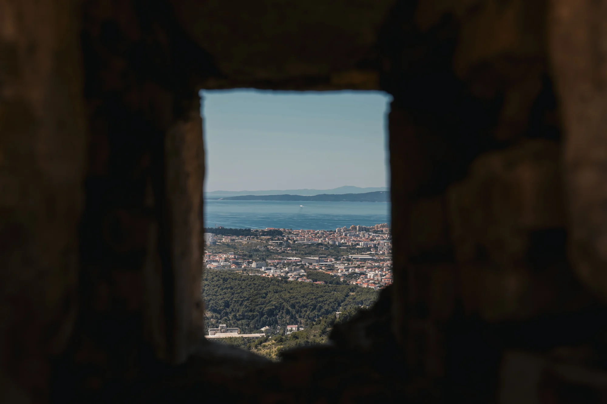 Split waterfront seen through a stone opening